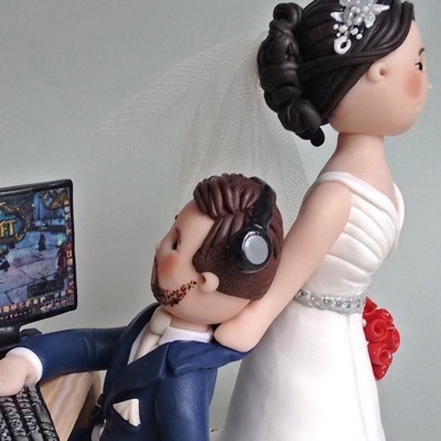 Wedding cake topper with groom playing video game