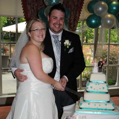 Couple cutting cake with cake topper