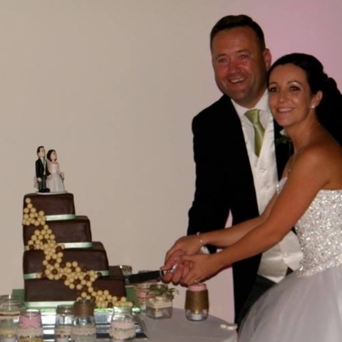 Couple cutting chocolate cake with cake topper