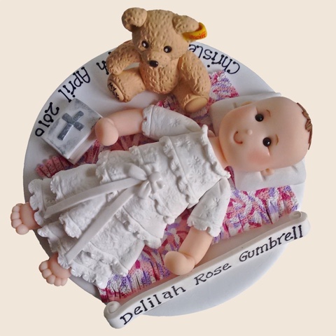 Hand-crafted christening cake topper of baby with teddy-bear